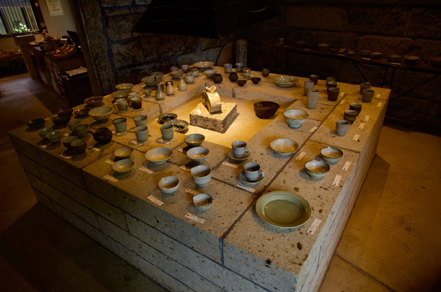 The north stone warehouse gallery: bowls and cups set out on a large square sunken stone platform