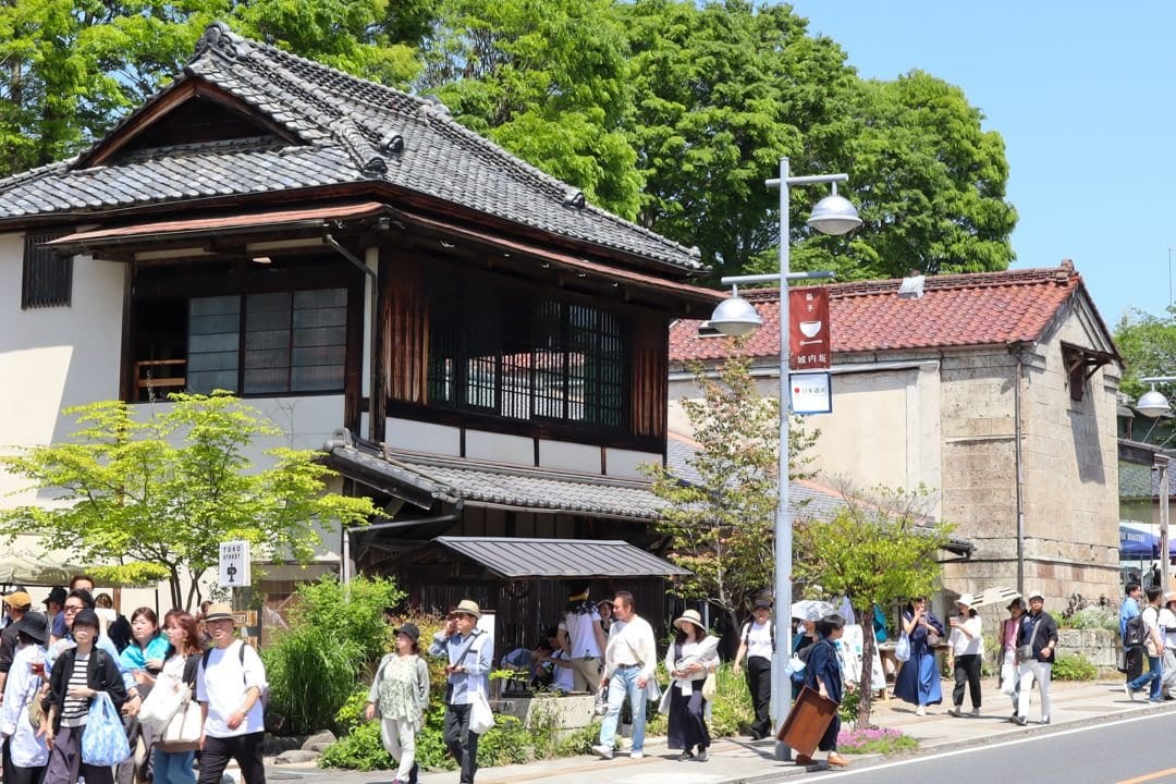 陶器市期間中の城内坂通り。陶庫の木造商家と石蔵の前を多くの来場者が歩いている