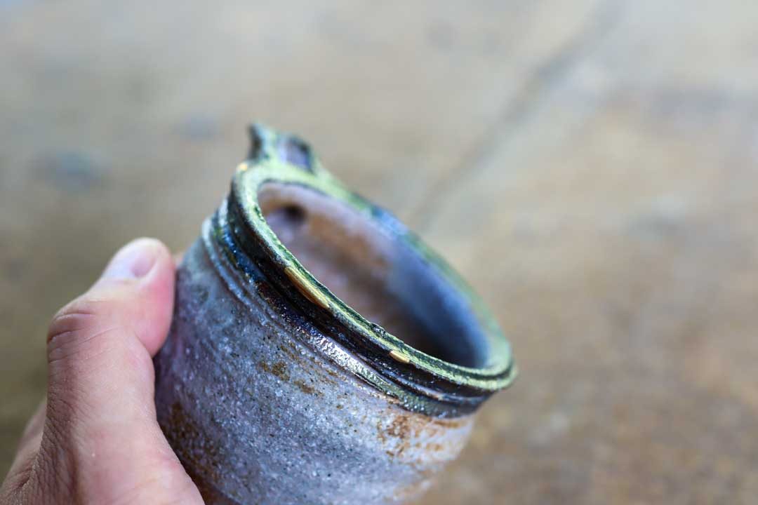 口縁の欠けを金で直した器を手に持った様子