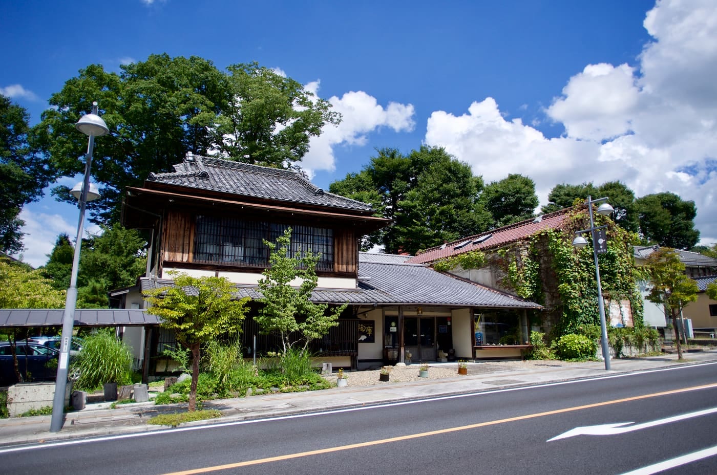 城内坂に面した陶庫の外観。瓦屋根の木造2階建て商家と、その右に蔦の絡む石蔵