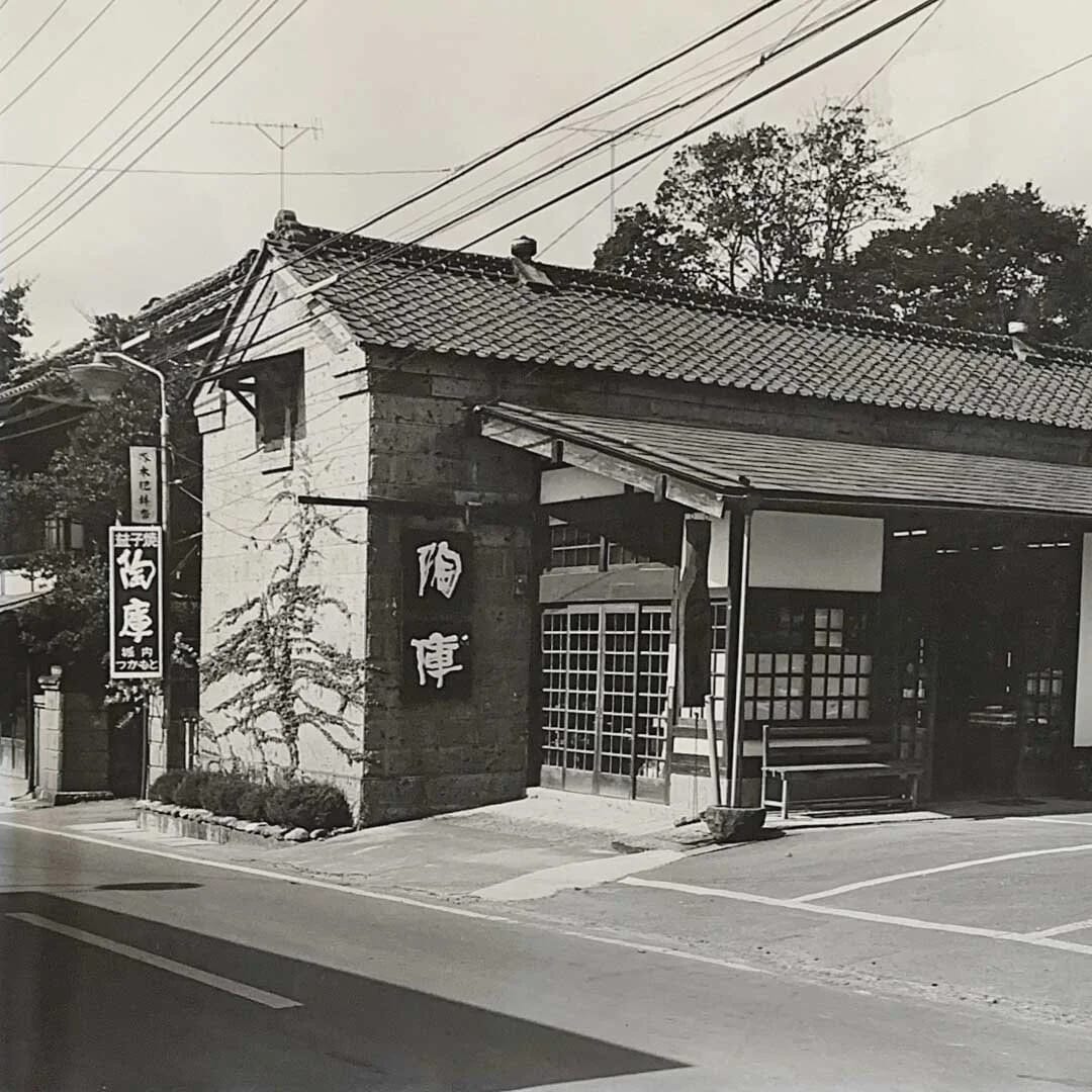 創業当初の陶庫のモノクロ写真。角地の石蔵に「陶庫」の看板と暖簾が掛かる